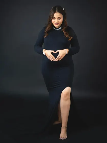 A beautiful moment of connection as the mom-to-be makes a heart shape over her baby bump. A simple, loving gesture captured forever.