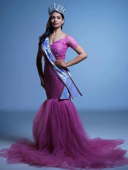 A full-length view of the pageant winner in the pink mermaid gown, showcasing the crown and sash. This gown is truly fit for a queen.