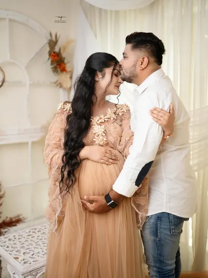 A sweet kiss on the forehead. This gesture of love and protection is a beautiful moment to capture as the couple celebrates their journey to parenthood.