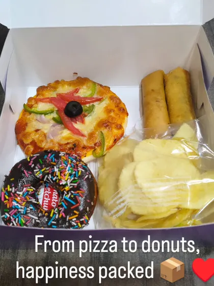 Mini pizza, spring rolls, chips and a sprinkled chocolate donut make up this snack combination we pack in a white box.