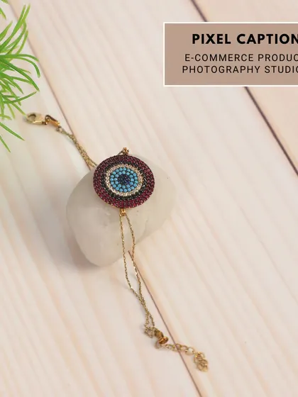 A creative shot of a bracelet styled with a white stone and a plant. This brings a fresh, natural element to the product photography, ideal for lifestyle brands.