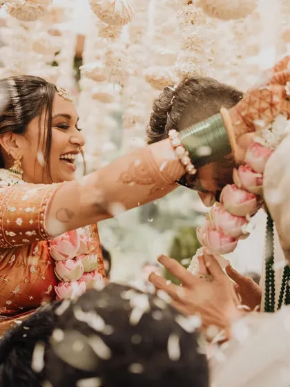 The pure joy of the "Varmala war". We ensure our photographers are right there to capture the laughter and playful banter that make weddings so memorable.