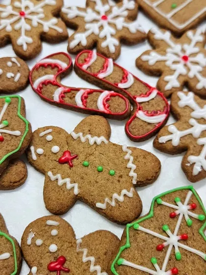 A close-up of our hand-decorated gingerbread cookies for Christmas. Each cookie, from the gingerbread men to the candy canes and snowflakes, is decorated with royal icing to bring out the festive details.