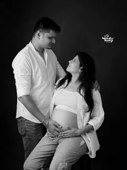A relaxed, modern couple's portrait in black and white. The casual outfits and intimate pose create a natural and authentic feel.
