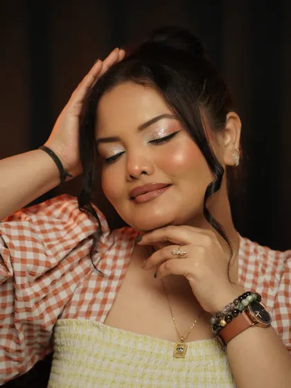 This look is all about being soft, glowy, and juicy. With eyes closed, you can see the glittery winged liner and the radiant skin, a perfect example of effortless glam.