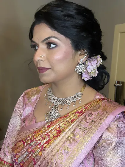 A beautiful example of how to incorporate fresh flowers into a hairstyle. The makeup is soft and romantic to match, creating a cohesive and elegant look.