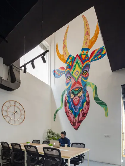A large, colorful mural serves as a powerful focal point in this open work area. We use large-scale art to inject personality and energy into our office designs, turning a simple wall into a source of inspiration.