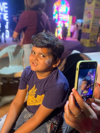 A young basketball fan getting a custom design on his forehead.