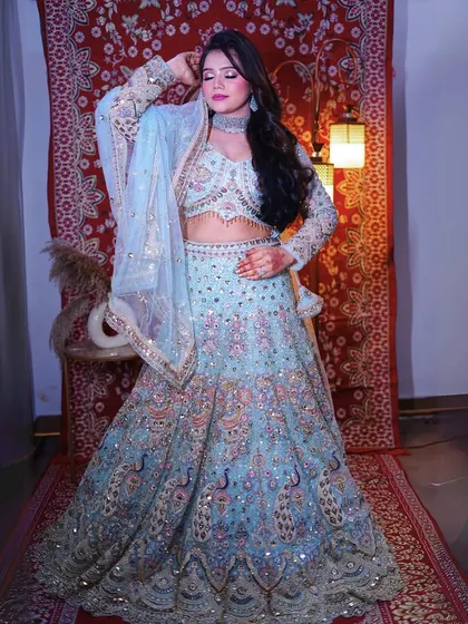 This full-length shot captures the grandeur of our sky-blue bridal lehenga, featuring intricate peacock designs all over the skirt.
