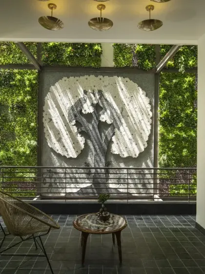 At the rear of Ashraya Residence, a striking mural of a tree is framed by a dramatic 40-foot-high vertical green wall. This feature creates a compelling confluence of art, nature, and cultural identity.