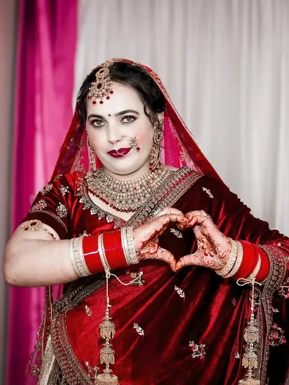 A happy bride making a heart shape with her hands. This pose is full of love and joy, a perfect expression of her feelings on the wedding day.