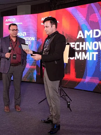 Performing a digital magic routine with an audience volunteer at the AMD summit. This trick involves their device, making the magic feel personal and modern.