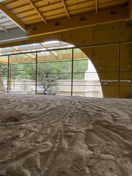The interior of a commercial building during its transformation. The raw floor and exposed new structural arches hint at the open, flexible office spaces to come, designed to meet the needs of modern information-driven businesses.