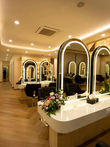 From this angle, you can see the cohesive design language that connects the different zones of the salon. The repetition of the arched mirrors and the clean lines of the workstations create a visually pleasing and organized space.