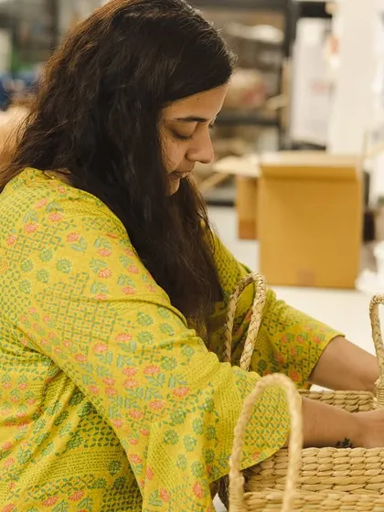 A member of our packing team carefully placing items into the Kauna baskets. It's a meticulous process that requires focus and a gentle touch.
