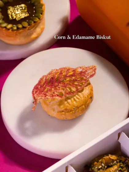 A Corn & Edamame Biskut, topped with a delicate, crispy lattice. A savory pastry that is both beautiful and delicious.