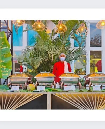 A South Indian cuisine counter with a tropical theme, featuring a menu written on a banana leaf and our chefs ready to serve.