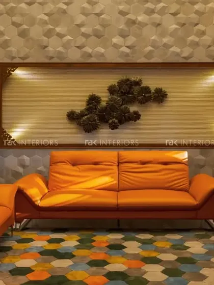 An eclectic living room with a bright orange sofa set against a 3D-paneled wall and a colorful hexagonal rug.