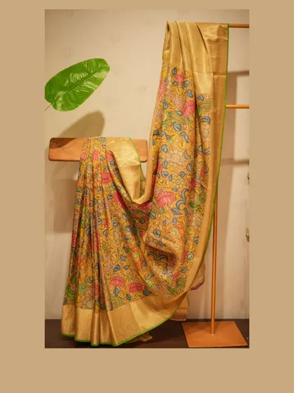 A beautiful Tussar silk saree with an all-over, hand-painted Kalamkari design, showcasing a vibrant and artistic option for festive wear.