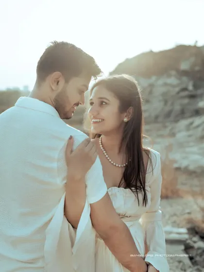 A sun-drenched pre-wedding portrait. The bright light and the couple's happy, loving expressions create a warm and joyful image.