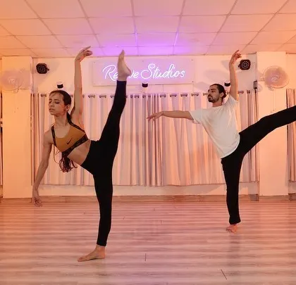 Dancers hold a challenging extension during a contemporary workshop. These sessions focus on building technique, strength, and flexibility in a collaborative environment.