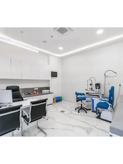 This consultation room is designed for both function and comfort. The space is bright, clean, and organized, with modern medical equipment integrated into a minimalist design featuring white cabinetry and marble-patterned floors.