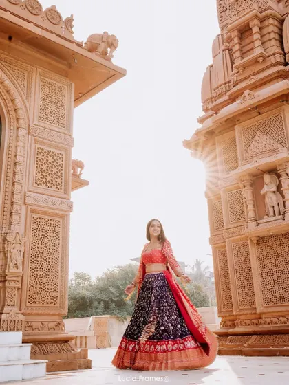 A beautiful shot of the bride standing between two temple structures, with the sun creating a starburst effect.