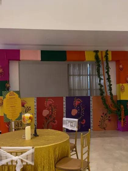 A colorful bar setup for a Diwali party. The bar front is decorated with vibrant, hand-painted panels, adding a festive and artistic touch to the celebration.