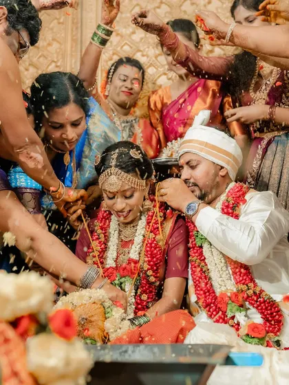 A candid shot of the couple surrounded by family during the 'Talambralu' rice showering ceremony, full of blessings and joy.