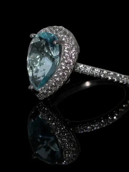 A true showstopper, this statement cocktail ring features a large, teardrop-shaped aquamarine-colored stone surrounded by a halo of sparkling zirconia. Crafted in pure 92.5 silver, it's designed for those special events where you want your jewelry to make an impact.