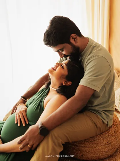A tender kiss on the forehead in a beautifully lit lifestyle maternity session. This image is full of warmth, love, and gentle anticipation.