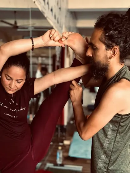 As part of our teacher training, I provide hands-on adjustments to ensure students understand the nuances of each pose, like this standing split.