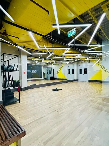 The group exercise studio at DLF Thrive, Chennai. With its wooden flooring, mirrored walls, and dynamic overhead lighting, this space is designed to be flexible and motivating for a variety of fitness classes.