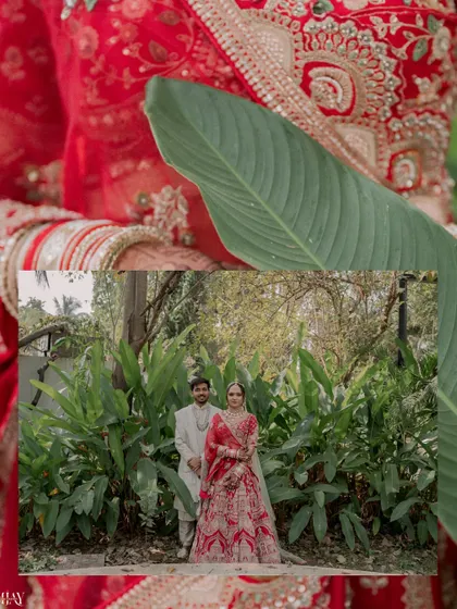 A creative shot of the couple framed by a large leaf, with a focus on the bride's stunning red lehenga.