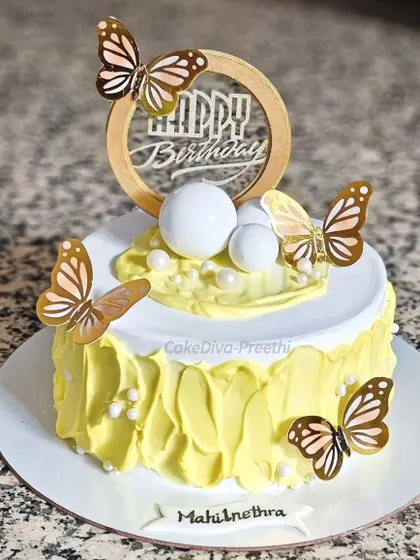 Fluttering happiness on a plate! This bright yellow cake uses a textured buttercream technique and is adorned with beautiful paper butterflies and delicate pearl sprinkles.