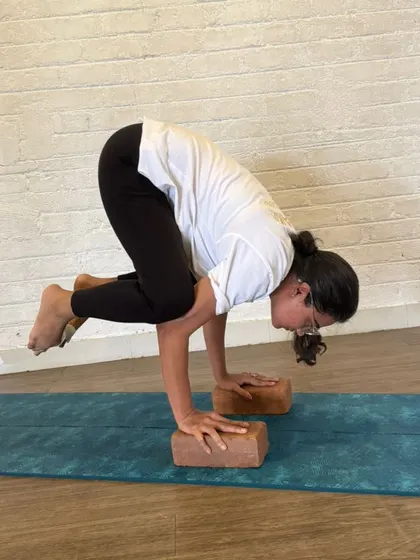 Finding the tipping point of balance in Bakasana is a lesson in mindfulness. Our TTC students learn to guide others through this process, addressing fear and building trust in one's own strength.