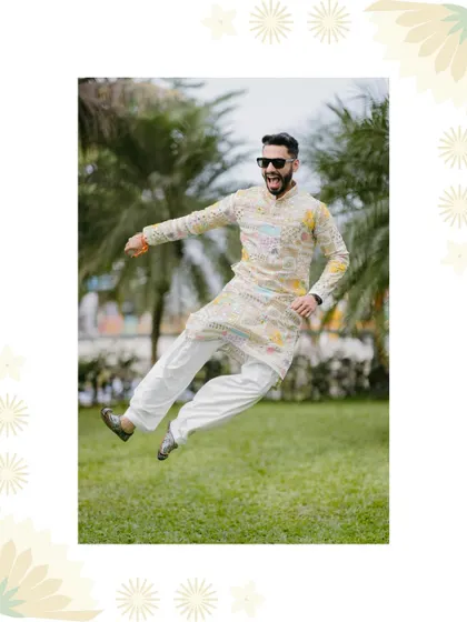 A groom jumps for joy in a garden, his energetic and happy mood perfectly captured during his Haldi celebration.