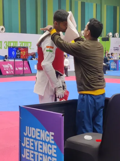 The role of a coach extends to the final moments before a match. Here I am offering final words of encouragement and strategy to a Karnataka athlete at the National Games.