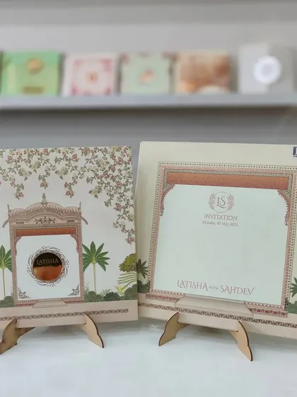 This pastel-themed invitation features a traditional Jharokha design, giving it a royal and architectural feel. The details are printed on high-quality paper.