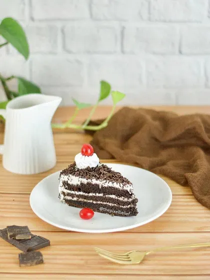 A slice of Black Forest cake is presented in a clean, bright setting with a minimalist aesthetic. This style of food photography is perfect for cafes, blogs, and modern brands.