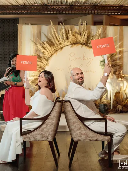 A snapshot from a chic and playful baby shower, where the parents-to-be are engaged in a fun game. This shows my expertise in planning all of life's milestones, with custom decor like the pampas grass wreath and personalized activities for guests.