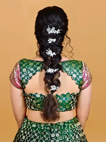 A detailed shot of the braided hairstyle for the half-saree look. I often collaborate with hairstylists to ensure the entire look is cohesive, from the makeup to the hair accessories.