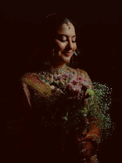 A beautiful, softly lit portrait of the bride holding her bouquet, her face glowing with happiness.