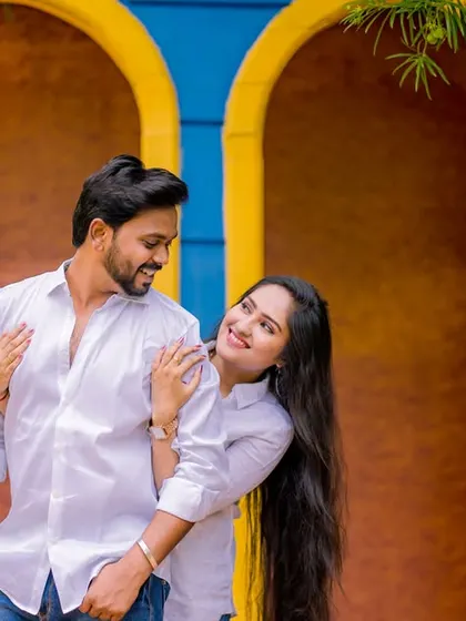 A loving gaze against a bright, colorful background. The couple's simple white shirts allow their connection and the vibrant setting to shine.