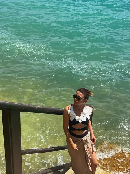 By the beautiful turquoise water. This black swimsuit with white floral appliqué is one of my more unique beachwear pieces.
