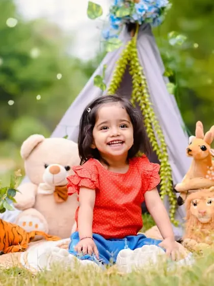 Anaya's second birthday shoot was set up as a fun picnic in the park. I bring all the props, like this teepee tent and adorable stuffed animals, to create a playful scene for your child.