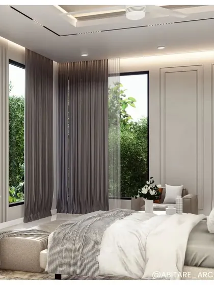 A pristine and lavish bedroom design. The space uses a neutral color palette, floor-to-ceiling windows with sheer curtains, and subtle wall paneling to create a bright, airy, and elegant room.