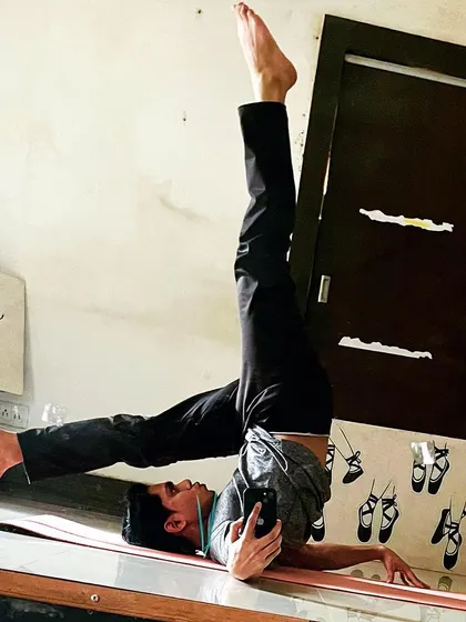 A variation of the shoulder stand, captured in a mirror selfie, highlighting the core control required.