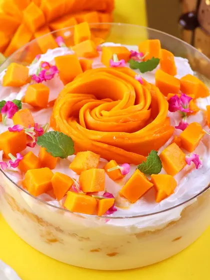 Another angle of our best selling Mango Tres Leches, showcasing the generous topping of fresh mango cubes and mint leaves.