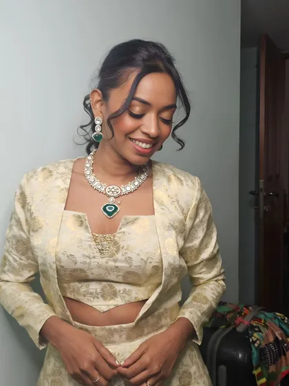A close-up of the final wedding guest look for Vaishnavi. The makeup features a soft, shimmery eye, glowing skin, and a gentle pink lip, paired with an elegant pulled-back hairstyle.